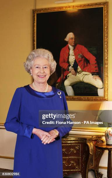 Queen Elizabeth II stands in the 18th Century Room at Buckingham Palace in front of a 1771 portrait by Johann Zoffany of George III, who was king for...