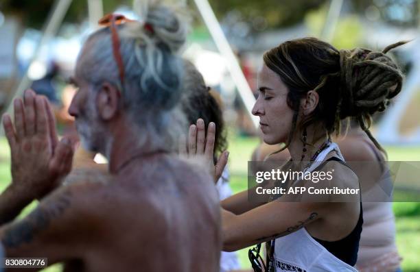 Participants name a 'namaste' gesture during the Rototom Sunsplash European Reggae Festival in Benicassim, Castellon province, on August 12, 2017....