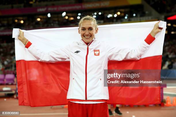 Kamila Licwinko of Poland celebrates with a flag after winning bronze in the Women's High Jump Final during day nine of the 16th IAAF World Athletics...