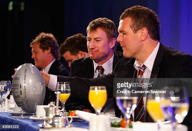 Steve Menzies of the Sea Eagles and team mate Jason King inspect a commemorative football during the 2008 NRL Grand Final breakfast at the Westin...