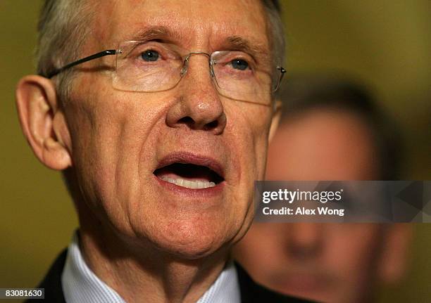 Senate Majority Leader Harry Reid speaks as Sen. Judd Gregg listens at a news conference following a vote on legislation drafted in response to the...