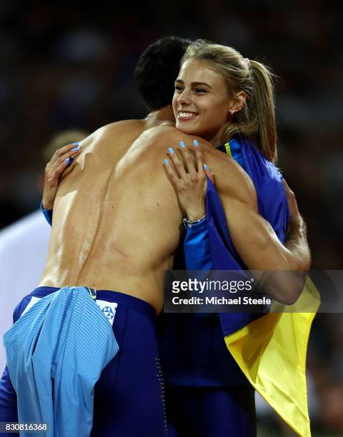 Yuliia Levchenko of Ukraine is ongratulated by Decathlon athlete Oleksiy Kasyanov after winning silver in the Women's High Jump Final during day nine...
