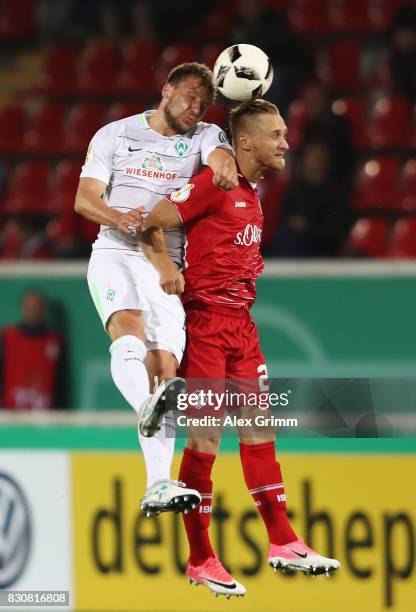 Philipp Bargfrede of Bremen jumps for a header with Bjoern Jopek of Wuerzburg during the DFB Cup first round match between Wuerzburger Kickers and SV...