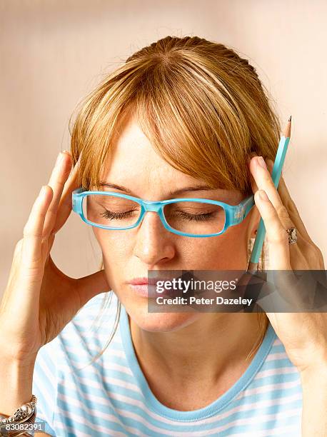 woman in glasses concentrating - concentration stockfoto's en -beelden