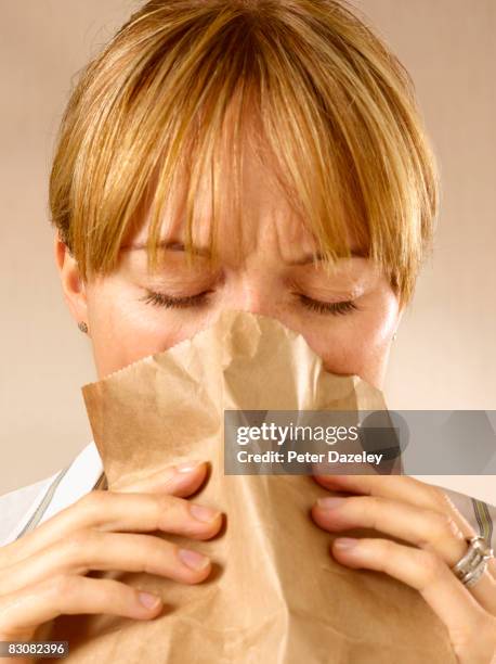 woman hyperventilating into bag - sick bag stock pictures, royalty-free photos & images