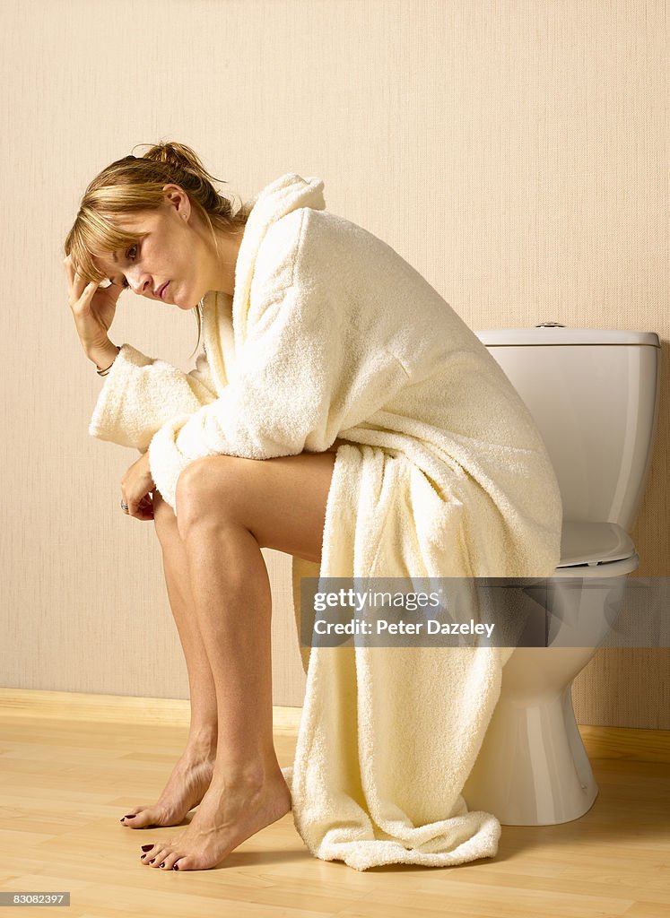 Woman with depression on toilet seat