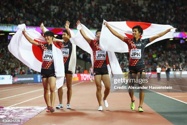 Shuhei Tada, Shota Iizuka, Yoshihide Kiryu and Kenji Fujimitsu of Japan celebrate winning bronze in the Men's 4x100 Relay final during day nine of...