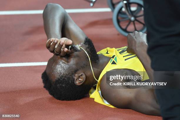 Jamaica's Usain Bolt lies on the track after pulling up injured in the final of the men's 4x100m relay athletics event at the 2017 IAAF World...