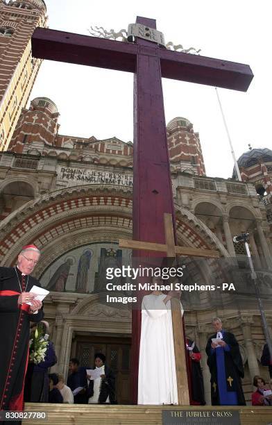 Archbishop of Westminster, Cardinal Murphy-O'Connor stands by as deputy head prefect of Cardinal Vaughan Memorial School, Ben Goddard holds a large...