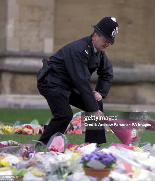 Policeman places flowers down at Windsor Castle following the death of Queen Elizabeth, the Queen Mother, on Saturday. She was 101. The coffin of the...