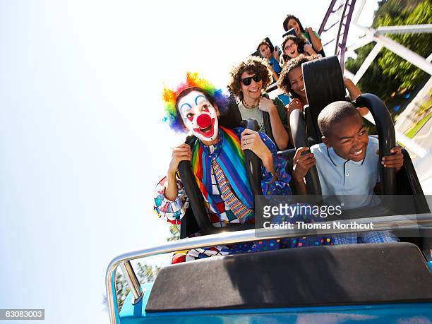 clown und menschen auf einer achterbahn - achterbahn stock-fotos und bilder