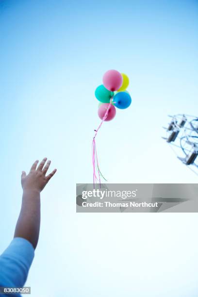 boy letting go of balloons  - releasing balloons stock pictures, royalty-free photos & images