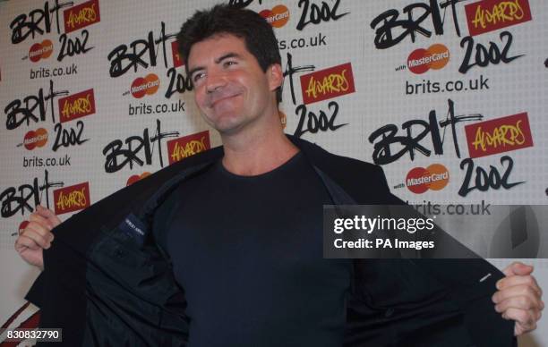 Presenter at the annual Brit awards Simon Cowell shows off his jacket to the photographers backstage at the awsrds in London. Cowell one of the...