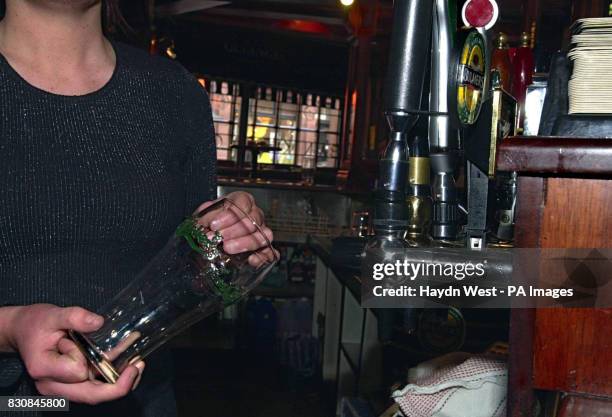 Barmaid in the Temple Bar, Dublin, cleans a glass, as bar steward unions announce possible strike action in Ireland during the World Cup unless they...