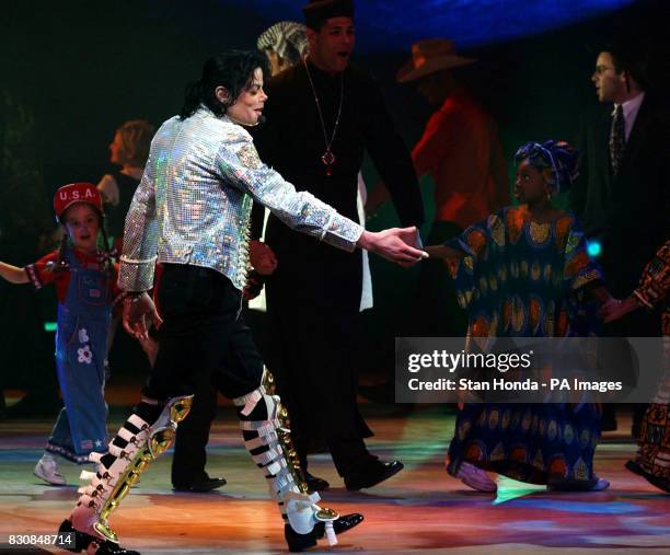 Singer Michael Jackson on stage with performers dressed in various ethnic costumes during "A Night at the Apollo" as part of a voter registration...