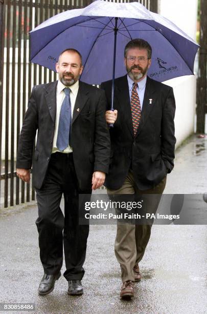 Sinn Fein president Gerry Adams shields Dublin Central General Election hopeful Nicky Kehoe from the heavy rain at a polling station in Cabra,...
