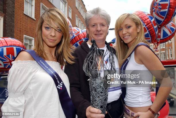 Jenny Frost and Liz McClarnon of girl group Atomic Kitten with the Chairman of the Golden Jubilee Summer Party Bruno Peek OBE, carry the Millenniun...