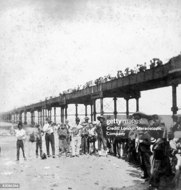 Musical troupe entertains the holidaymakers under Margate Pier, circa 1860.