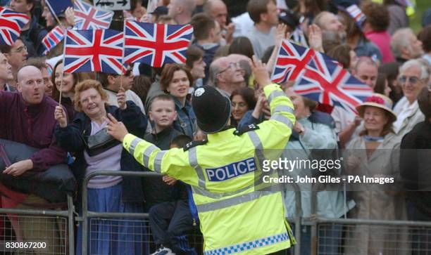 Police officer in the Mall conducts the crowd in the celebrations at Buckingham Palace, during the Pop Concert to celebrate the Golden Jubilee of the...