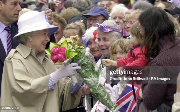 Britain's Queen Elizabeth II gathers flowers from wellwishers as she tours Leicester city centre, on the latest leg of her Jubilee tour of the UK....