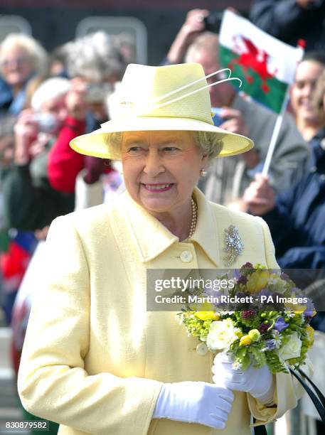 Britain's Queen Elizabeth II carries flowers as she walks on the station at Llanfair PG at the start of her three day Golden Jubilee visit to Wales....