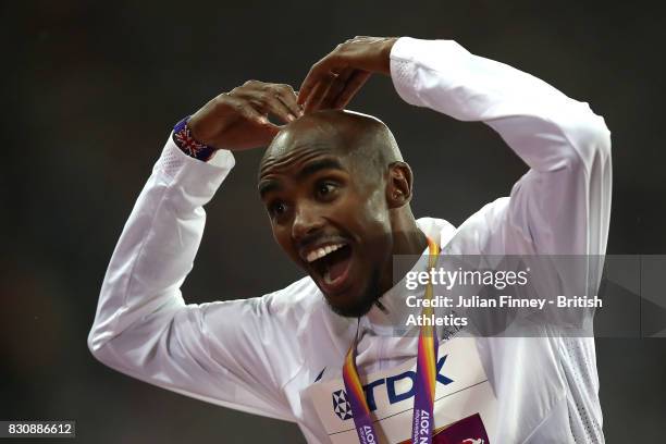 Mohamed Farah of Great Britain celebartes on the podium by doing the 'mobot' after being presented with his silver medal after finishing second in...