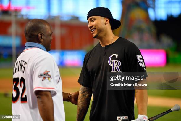 Former player and Hall of Famer Tim Raines greets Carlos Gonzalez of the Colorado Rockies before the game between the Miami Marlins and the Colorado...