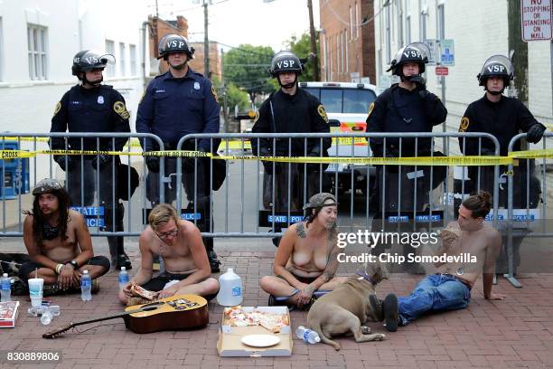 Members of the Virginia State Police stand guard near the intersection where a car plowed through a crowd of demonstrators, killing one person,...