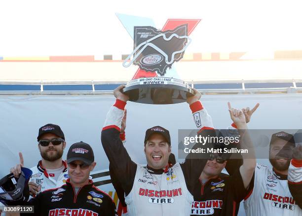 Sam Hornish Jr., driver of the Discount Tire Ford, celebrates in victory lane with the trophy after winning the NASCAR XFINITY Series Mid-Ohio...