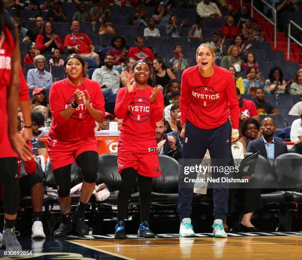 Elena Delle Donne, Ivory Latta and Tianna Hawkins of the Washington Mystics react to a play from courtside against the Indiana Fever on August 12,...