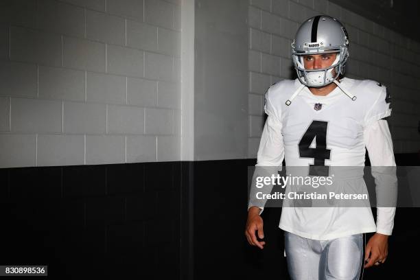 Quarterback Derek Carr of the Oakland Raiders walks out onto the field before the NFL game against the Arizona Cardinals at the University of Phoenix...