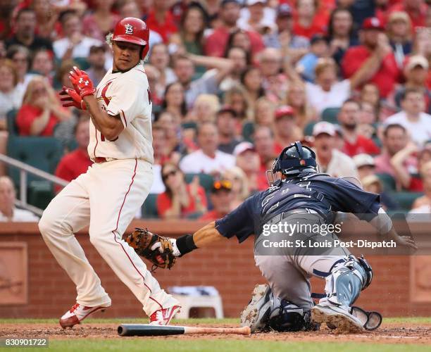 The St. Louis Cardinals' Carlos Martinez, left, avoids the tag attempt by Atlanta Braves catcher Kurt Suzuki as he scores on a single by Tommy Pham...