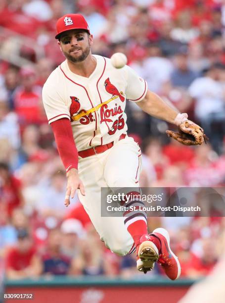 St. Louis Cardinals third baseman Greg Garcia recovers a ball deflected by pitcher Carlos Martinez and tries to throw out the Atlanta Braves' Ozzie...