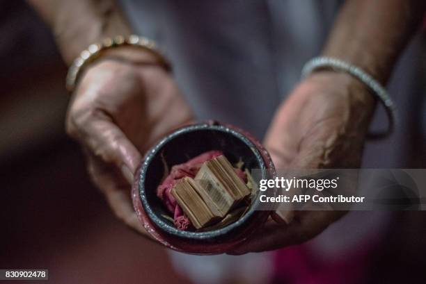 In this photograph taken on August 4 Shah Jahan Begum the wife of Indian Partition survivor Saleem Hasan Siddiqui, poses for a photograph with a...