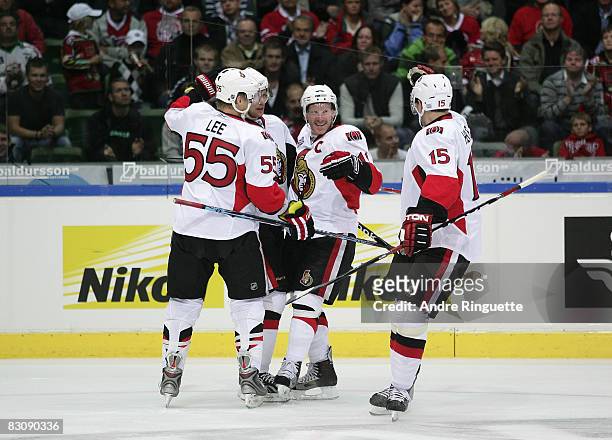 Daniel Alfredsson of the Ottawa Senators celebrates his first period goal against the Frolunda Indians with teammates Brian Lee and Dany Heatley at...
