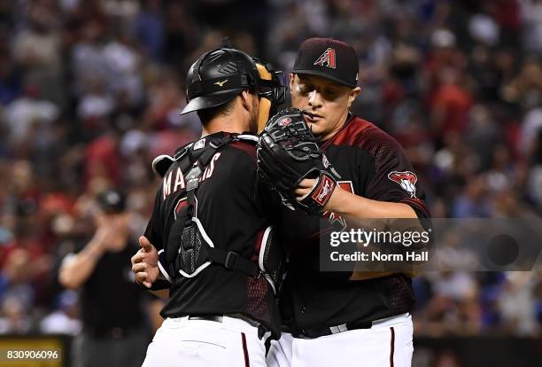 David Hernandez and Jeff Mathis of the Arizona Diamondbacks celebrate a 6-2 win against the Chicago Cubs at Chase Field on August 12, 2017 in...