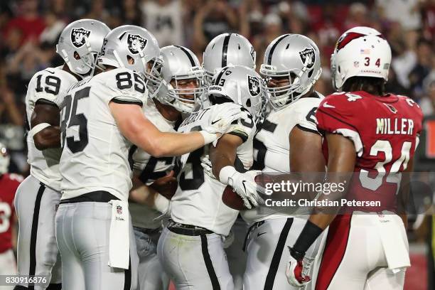 Running back John Crockett of the Oakland Raiders is congratulated by Jaydon Mickens, Ryan O'Malley and Jordan Simmons after Crockett scored on a one...