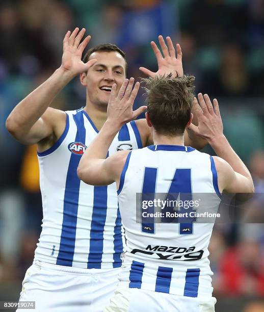 Braydon Preuss of the Kangaroos celebrates with Trent Dumont after scoring a goal during the round 21 AFL match between the Hawthorn Hawks and the...