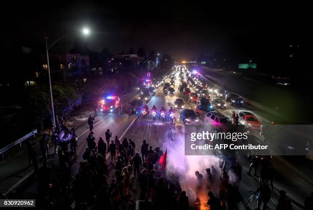 Protesters block both directions of the Interstate 580 freeway during a rally against racism in Oakland, California on August 12, 2017. Protesters...
