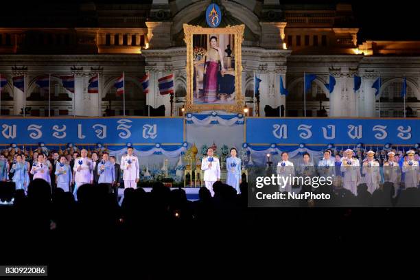 Thai Prime Minister Prayut Chan-o-cha and his wife Naraporn light a candle in front of a large picture of Thai Queen Sirikit, to celebrate of Queen...