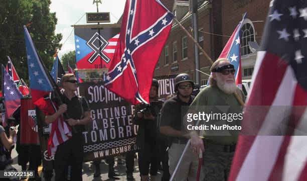 Free speech demonstrators march holding flags and banners during the Unite the Right free speech rally at Emancipation Park in Charlottesville,...