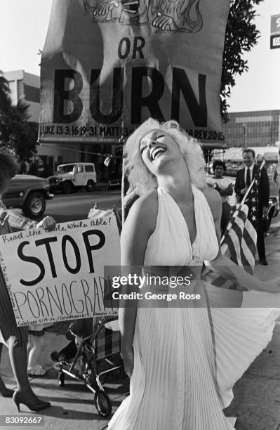 Mariyln Monroe look-alike entertains a crowd of onlookers outside the 1980 Hollywood, California, Adult Entertainment Awards held at the Palladium.