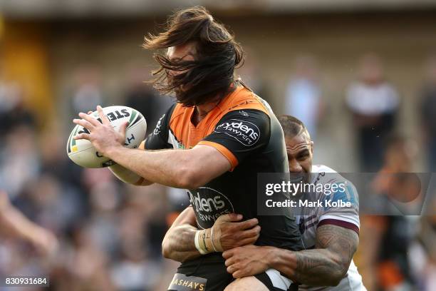 Aaron Woods of the Tigers is tackled during the round 23 NRL match between the Wests Tigers and the Manly Sea Eagles at Leichhardt Oval on August 13,...