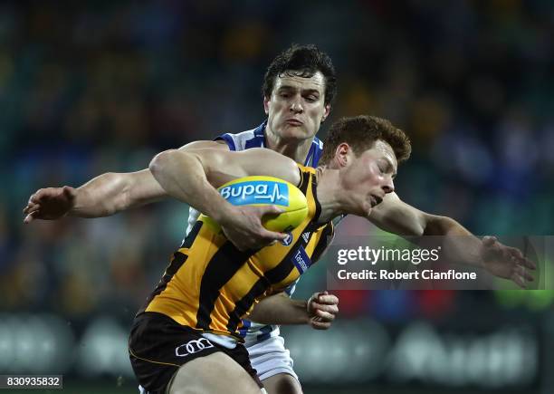 Tim O'Brien of the Hawks is challenged by Scott Thompson of the Kangaroos during the round 21 AFL match between the Hawthorn Hawks and the North...