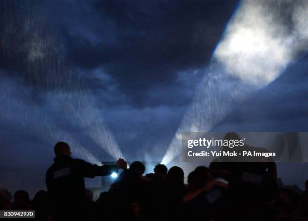 Crowds brave the rain to watch Muse performing on the Main Stage at the Reading Festival, Saturday 24 August 2002. PA Photo : Yui Mok