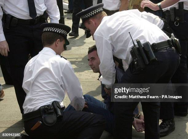 Police officers detain a man at a rally for the Muslim group Al-Muhajirou in London's Trafalgar Square.