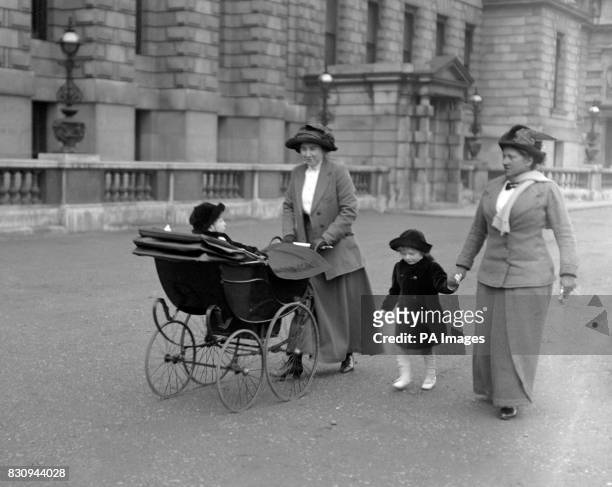 Diana Churchill, daughter of Winston Churchill, walking in Whitehall with her nurse. In the perambulator is Randolph Churchill.