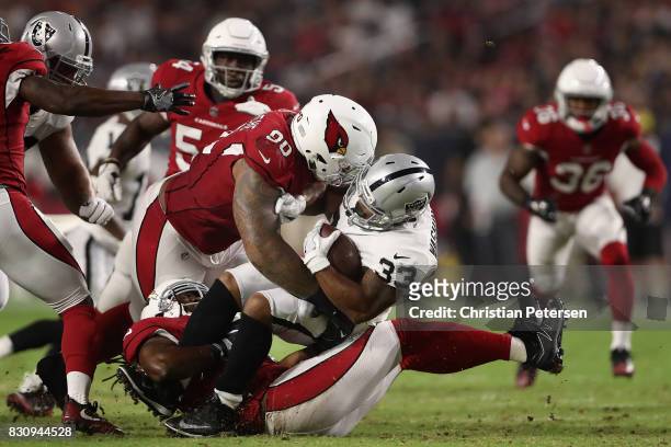 Defensive tackle Robert Nkemdiche of the Arizona Cardinals tackles running back DeAndre Washington of the Oakland Raiders for a loss during the...
