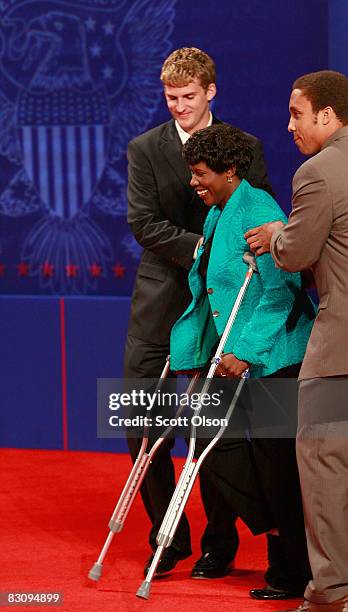 Journalist and debate moderator Gwen Ifill is helped to her seat prior to the start of the vice presidential debate at the Field House of Washington...