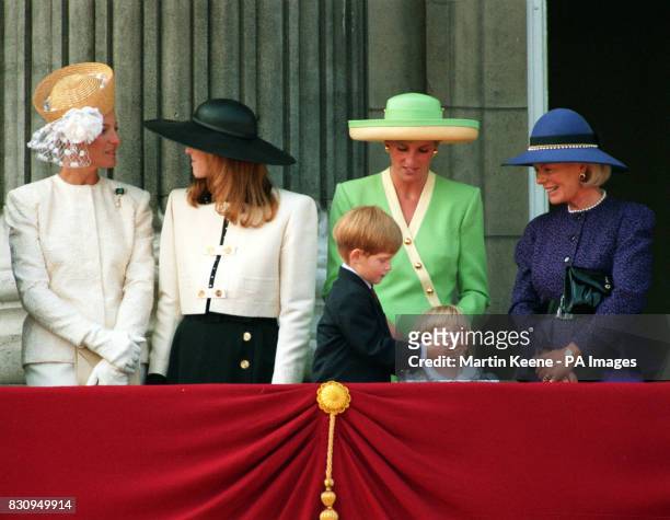 Prince Harry, on his sixth birthday, puts his hand over the mouth of two year old Princess Beatrice as they join the Princess of Wales and other...